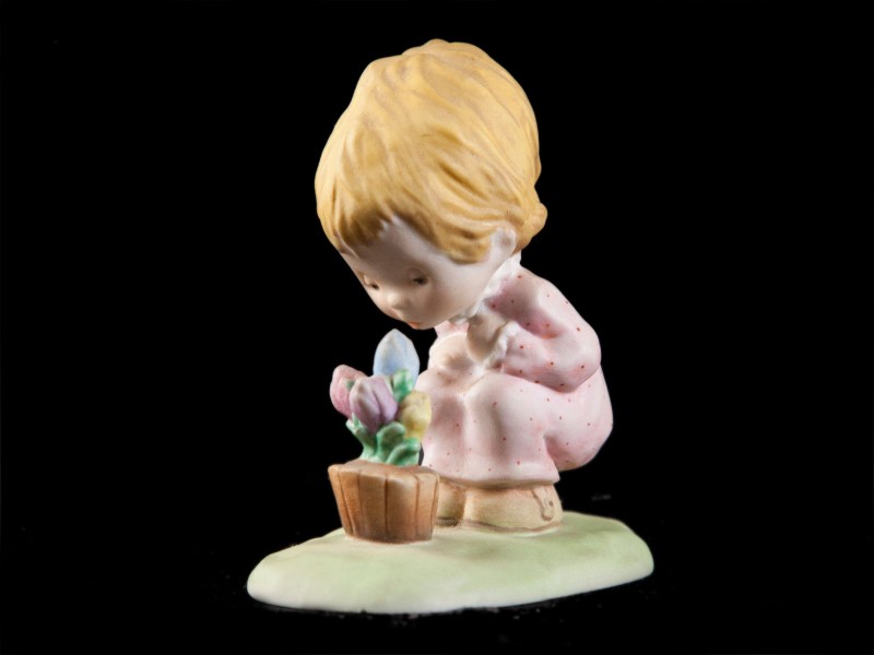 MENINA A OBSERVAR VASO COM FLORES