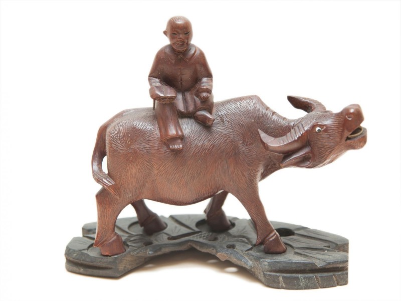 BÚFALO D’ÁGUA COM FIGURA MASCULINA NO DORSO
