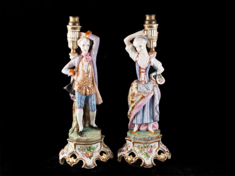 PAR DE CASTIÇAIS EM PORCELANA REPRESENTANDO “CASAL DE FIGURAS ILUSTRES”