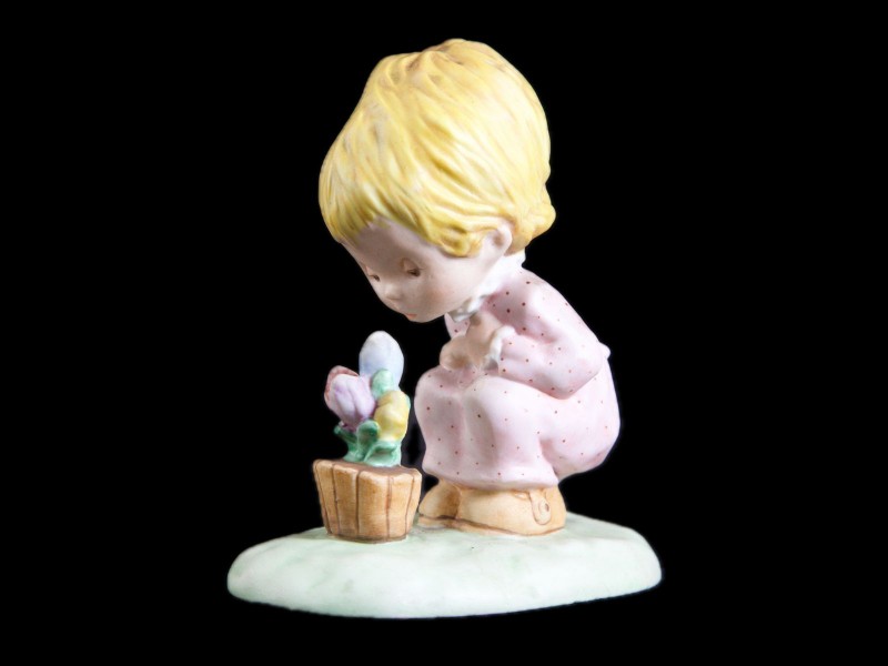 MENINA A OBSERVAR VASO COM FLORES